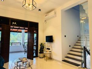 a living room with a staircase and a tv at Jungle Breeze Villa in Melsiripura
