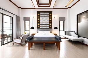 a bedroom with a bed and a couch and chairs at Wonderland Resort Chiangmai in Chiang Mai