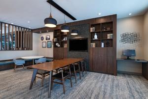 a dining room with a table and chairs and a tv at Four Points by Sheraton Fort Worth North in Fort Worth