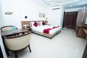 a hotel room with a bed and a desk at Hotel SVM Grand Koti in Hyderabad
