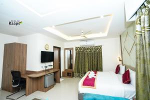 a hotel room with a bed and a desk at Hotel SVM Grand Koti in Hyderabad