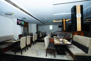 a dining room with tables and chairs and a television at Hotel SVM Grand Koti in Hyderabad