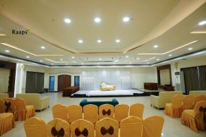 a room with chairs and a bed in the background at Hotel SVM Grand Koti in Hyderabad +1 photo