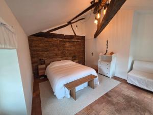 a bedroom with a white bed and a brick wall at Les terrasses de la moine in Cholet