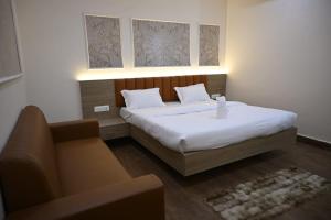 a small bedroom with a bed and a couch at Hota Residency in Sonepur +25 photos