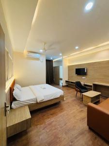 a hotel room with a bed and a television at Hota Residency in Sonepur