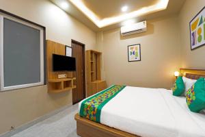 a bedroom with a large bed and a television at Anandam Hotel in Jaipur