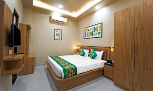 a bedroom with a bed and a flat screen tv at Anandam Hotel in Jaipur +12 photos