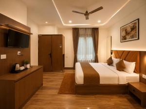a hotel room with a bed and a television at Hotel Grand Lucent Mathura-Vrindavan in Gokul