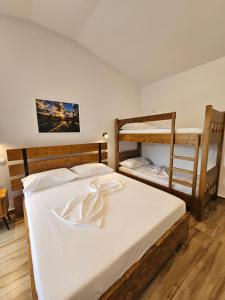 a bedroom with two bunk beds with white sheets at Bungalows at Mali Camp Kruje with Pool in Krujë +45 photos
