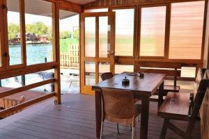 a room with a wooden table and chairs on a boat at Kucica Enterprise-Ada Bojana in Ulcinj