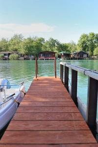 a wooden dock with a boat on the water at Kucica Enterprise-Ada Bojana in Ulcinj