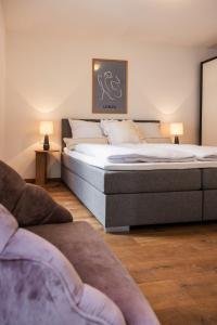 a bedroom with a large bed and a couch at Helles Penthouse mit Dachterrasse & Bergblick in Mondsee