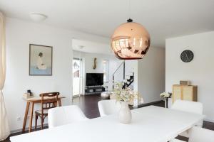 a white dining room with a white table and white chairs at Helles Penthouse mit Dachterrasse & Bergblick in Mondsee