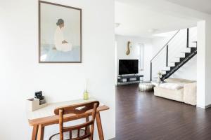 a white living room with a table and a staircase at Helles Penthouse mit Dachterrasse & Bergblick in Mondsee