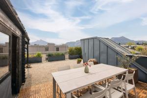 an outdoor patio with a white table and chairs at Helles Penthouse mit Dachterrasse & Bergblick in Mondsee