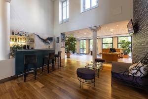 a lobby with chairs and a bar in a building at HOTEL CERISE - LES SOURCES Luxeuil-les-Bains in Luxeuil-les-Bains