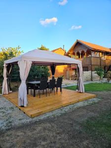 a gazebo with a table and chairs under it at Вила ДАР in Gara Oreshets