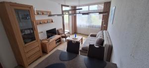 a living room with a couch and a television at Ferienresort mit Pool am Schluchsee in Schluchsee