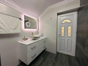 a white bathroom with a sink and a mirror at Nistor House-Delta Retreat in Tulcea