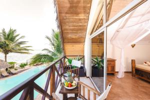 a room with a view of a pool and a house at Clove Island Villas & Spa in Makunduchi