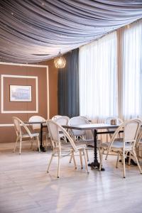 a dining room with a table and chairs and curtains at Seti Mestia Hotel in Mestia