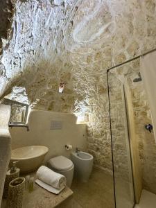 a bathroom with a sink and a toilet in a cave at Trullo Moi in Ostuni +78 photos