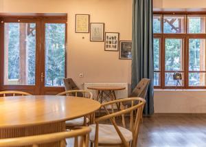 a dining room with tables and chairs and windows at Seti Mestia Hotel in Mestia