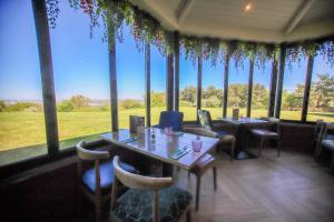 a restaurant with tables and chairs and a large window at Forest Hills Hotel & Country Club in Frodsham