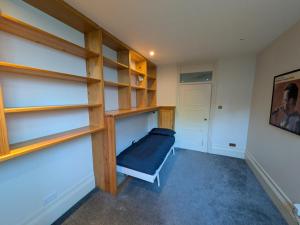 a room with wooden shelves and a bed in it at Hidden get away in Lewes in Lewes