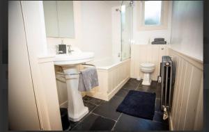 a bathroom with a sink and a tub and a toilet at Hidden get away in Lewes in Lewes +11 photos