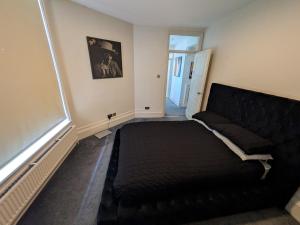 a bedroom with a black bed and a couch at Hidden get away in Lewes in Lewes