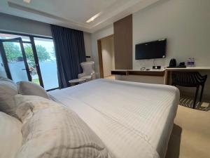 a hotel room with a bed and a desk and a television at Dusk and Dawn Beach Resort in Rāmeswaram