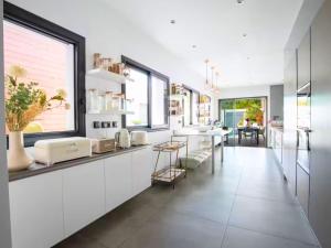 a kitchen with white cabinets and a large window at Grande Maison familiale - Piscine privée & Jardin clos - 10min Avignon & Château-neuf-du-Pape - Climatisation - Parking privé gratuit - Animaux admis in Sorgues