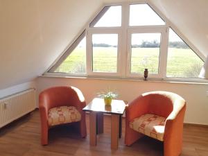 two chairs and a table in a room with a window at Fewo 18 im Strandhaus Lobbe mit Balkon in Lobbe +29 photos