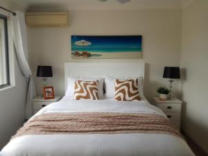 a bedroom with a bed and two night stands with lamps at "Casa Serena" - Spacious Entire Holiday Home in Caboolture