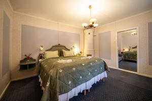 a bedroom with a large bed with a green comforter at Blankaholms Gästgiveri in Blankaholm