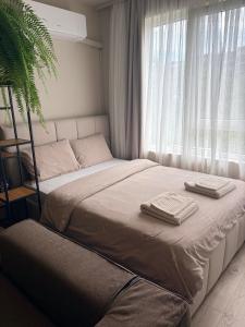a bedroom with a bed with two towels on it at Студио Bella in Varna City