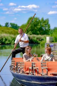 a man is rowing a boat with two women at Landhaus Brodack in Alt Zauche