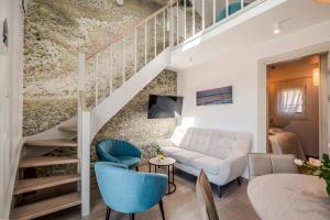 a living room with a staircase and blue chairs at Preilos Perliukas in Preila