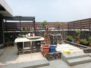 a patio with a table and some potted plants at Mahadev grand in Tirupati