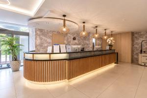 a lobby of a hotel with a counter and lights at AquaMed Hotel Harkány in Harkány