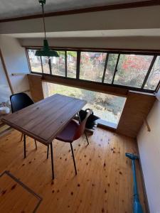 a dining room with a wooden table and chairs at かんぬしの宿 in Yamaguchi