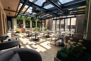 a patio with tables and chairs in a restaurant at Sapphire Hotel in Prizren