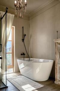 a large white tub in a bathroom with a window at Santa Barbara House in Ratiševina