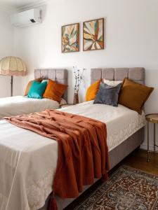 two beds in a room with orange and blue pillows at Santa Barbara House in Ratiševina +71 photos