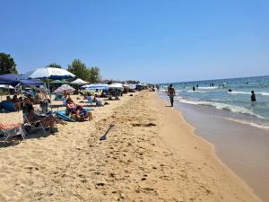a beach with many people and umbrellas and the ocean at Dinas house ofrinio in Ofrínion