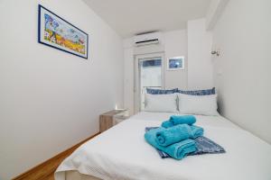 a bedroom with a white bed with blue towels on it at Melanie in Crikvenica