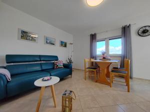 a living room with a blue couch and a table at Apartments Damir in Sveti Ivan Dobrinjski