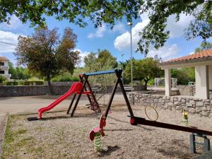 a child playing on a swing set in a park at Apartments Damir in Sveti Ivan Dobrinjski
